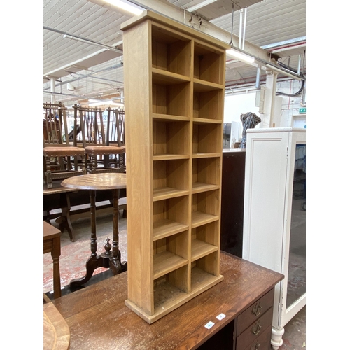 67 - A modern oak CD shelving unit - approx. 113cm high x 47cm wide x 17cm deep