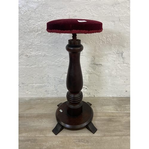 123 - A Victorian rosewood height adjustable revolving piano stool with red fabric upholstered seat - appr... 