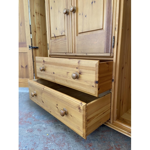 134 - A modern pine four door wardrobe - approx. 183cm high x 180cm wide x 62cm deep