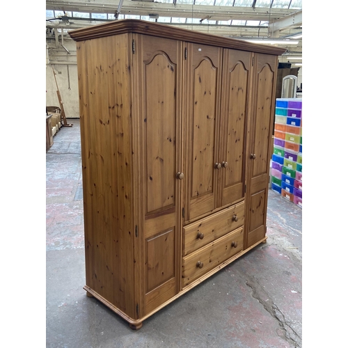 134 - A modern pine four door wardrobe - approx. 183cm high x 180cm wide x 62cm deep