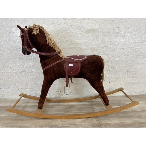 135 - A Victorian style brown fabric rocking horse with glass eyes on beech stand - approx. 100cm high x 3... 