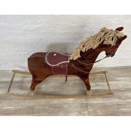 135 - A Victorian style brown fabric rocking horse with glass eyes on beech stand - approx. 100cm high x 3... 