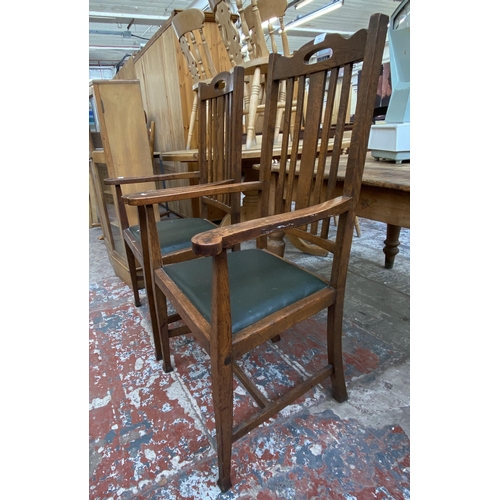 146 - A pair of Arts and Crafts oak and green vinyl upholstered carver dining chairs