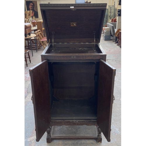 155 - A 1930s His Master's Voice carved oak gramophone cabinet - approx. 126cm high x 73cm wide x 60cm dee... 