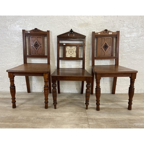 165 - Three 19th century carved hall chairs, two mahogany and one oak and mahogany with ceramic tile inser... 