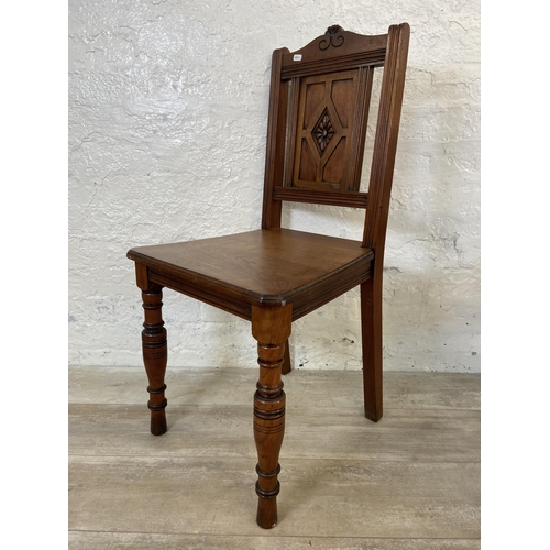 165 - Three 19th century carved hall chairs, two mahogany and one oak and mahogany with ceramic tile inser... 