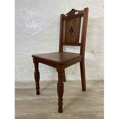 165 - Three 19th century carved hall chairs, two mahogany and one oak and mahogany with ceramic tile inser... 