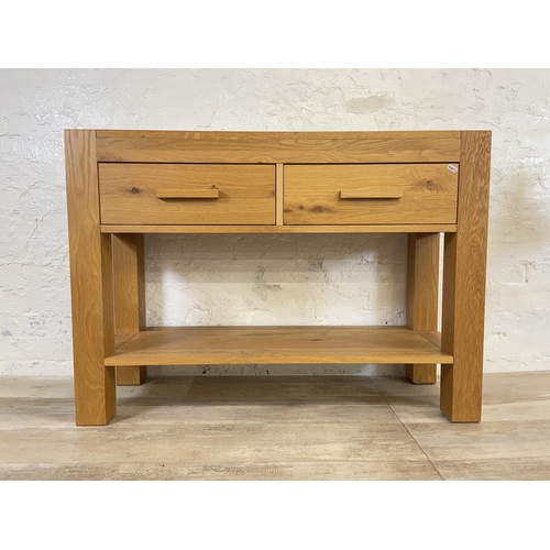 176 - A modern oak two drawer console table - approx. 70cm high x 110cm wide x 38 deep