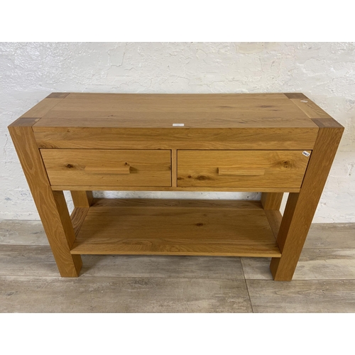 176 - A modern oak two drawer console table - approx. 70cm high x 110cm wide x 38 deep