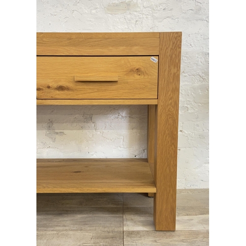 176 - A modern oak two drawer console table - approx. 70cm high x 110cm wide x 38 deep