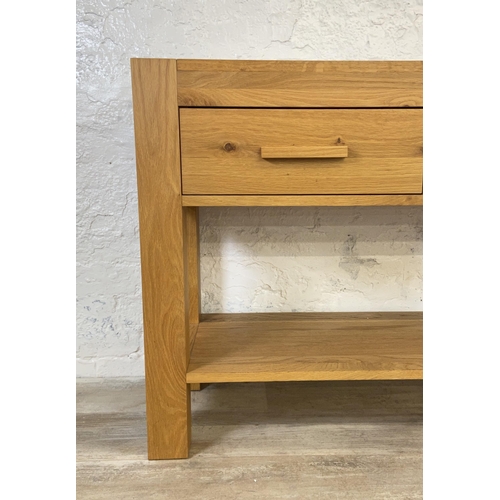 176 - A modern oak two drawer console table - approx. 70cm high x 110cm wide x 38 deep