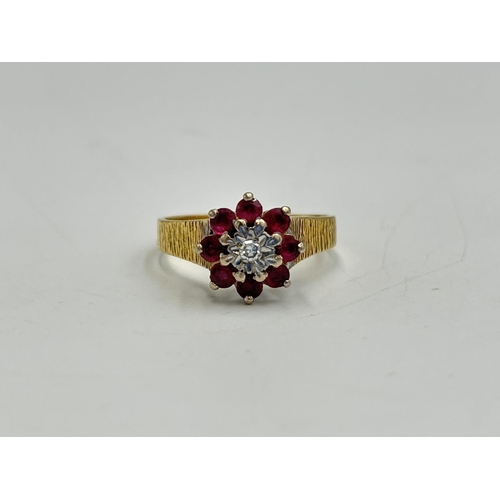 2209A - A hallmarked London 18ct gold ruby and diamond floral cluster ring with textured shoulders, size Q -... 