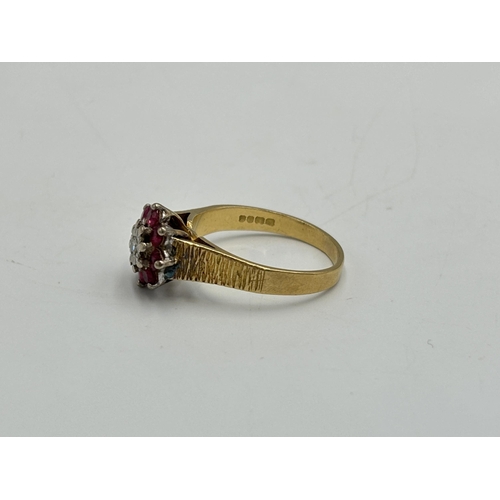 2209A - A hallmarked London 18ct gold ruby and diamond floral cluster ring with textured shoulders, size Q -... 