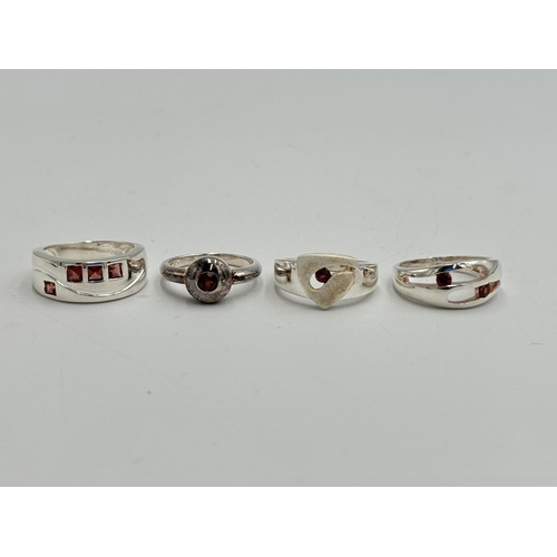 2255 - Four .925 silver garnet set dress rings - approx. gross weight 16.6g