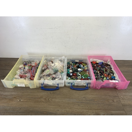 487 - Four boxes containing a large collection of glass pendants, charms and beads