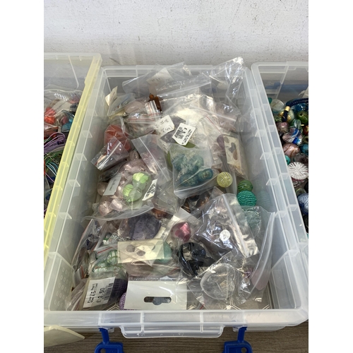 487 - Four boxes containing a large collection of glass pendants, charms and beads