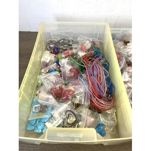 487 - Four boxes containing a large collection of glass pendants, charms and beads