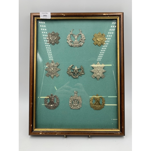 2431 - Nine framed military cap badges