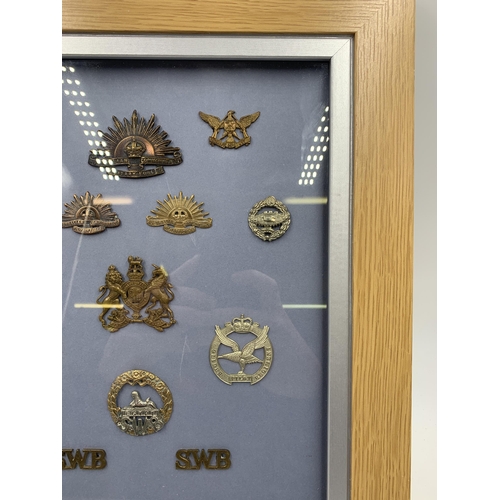 2441 - Eleven framed military cap badges together with two military shoulder titles