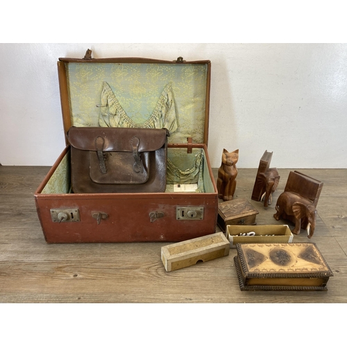 570 - A vintage brown leather suitcase containing a collection of items to include brown leather satchel, ... 