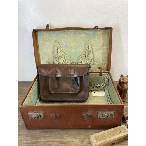 570 - A vintage brown leather suitcase containing a collection of items to include brown leather satchel, ... 