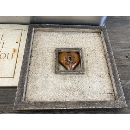 560 - An aluminium case containing a collection of cast stone wall plaques and signs