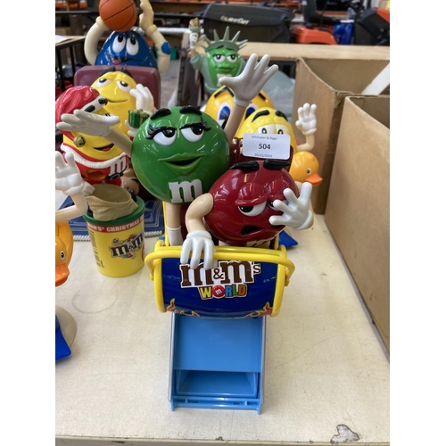 504 - Seven M&M's figurines together with one Pac-Man