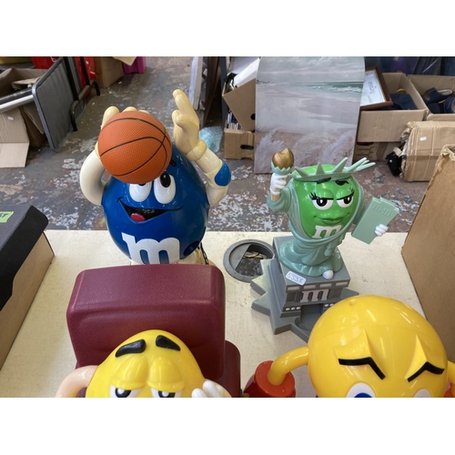 504 - Seven M&M's figurines together with one Pac-Man