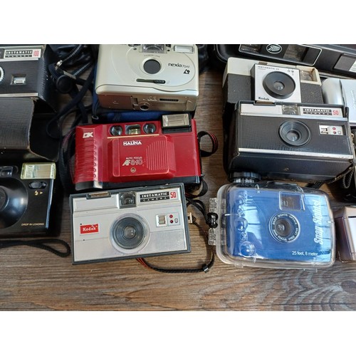 789 - A collection of cameras to include Canon, Yashica, Kodak, Fuji, Chinon, Halina, Ricoh, Hanimex etc.