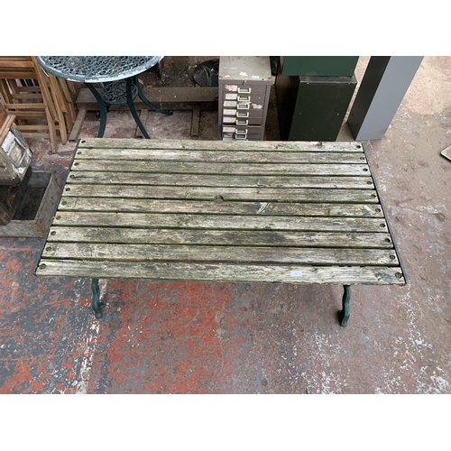 102 - Three pieces of garden furniture, one cast iron and green painted rectangular table and a pair cast ... 