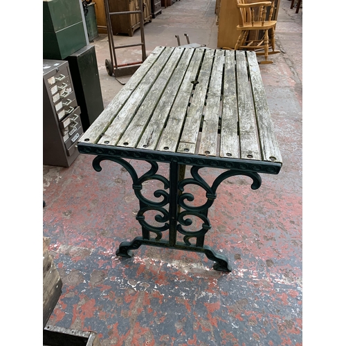 102 - Three pieces of garden furniture, one cast iron and green painted rectangular table and a pair cast ... 