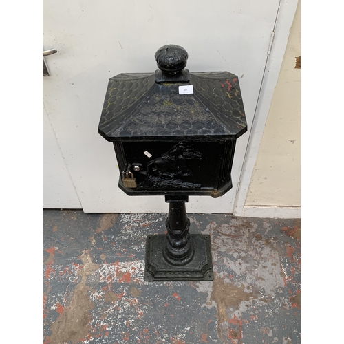 107 - A Victorian style cast iron and black painted post box on stand - approx. 117cm high