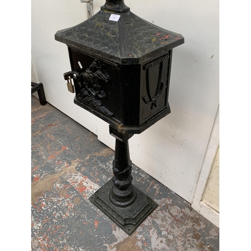 107 - A Victorian style cast iron and black painted post box on stand - approx. 117cm high