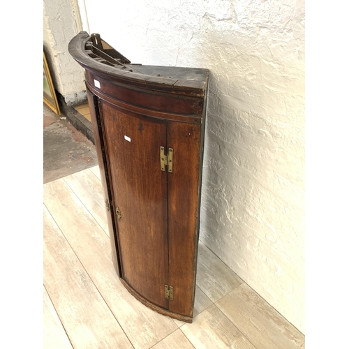 30 - A George III oak bow fronted wall hanging corner cabinet - approx. 106cm high x 74.5cm wide