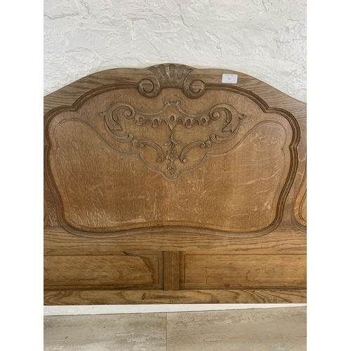 55 - A French Louis XV style oak double bed headboard and footboard