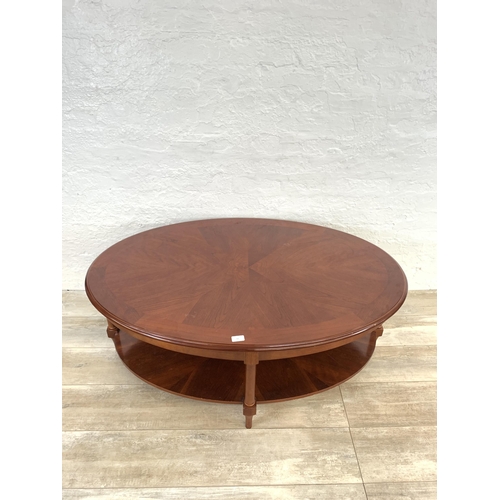 63 - A late 20th century mahogany oval two tier coffee table