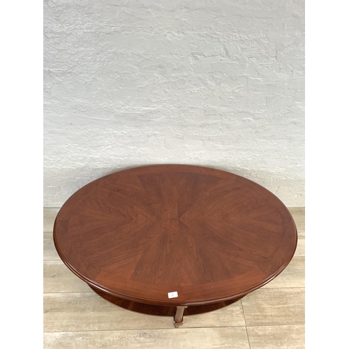 63 - A late 20th century mahogany oval two tier coffee table