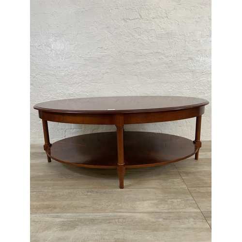 63 - A late 20th century mahogany oval two tier coffee table