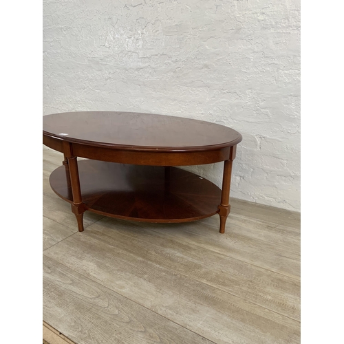 63 - A late 20th century mahogany oval two tier coffee table