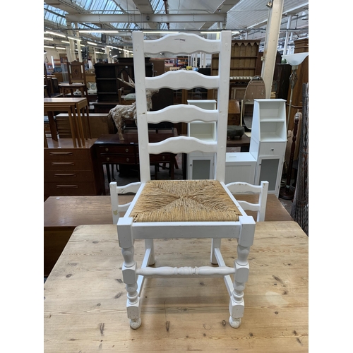 65 - A Victorian style white painted pine farmhouse dining table with four ladderback rush seated dining ... 