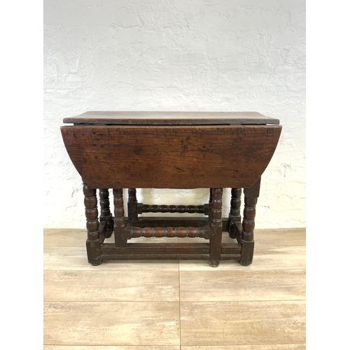 84 - An 18th century oak gate leg drop leaf dining table on bobbin supports