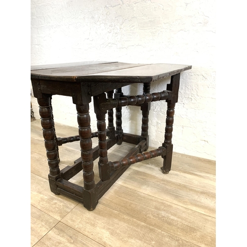 84 - An 18th century oak gate leg drop leaf dining table on bobbin supports