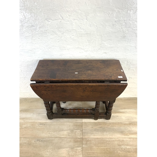 84 - An 18th century oak gate leg drop leaf dining table on bobbin supports