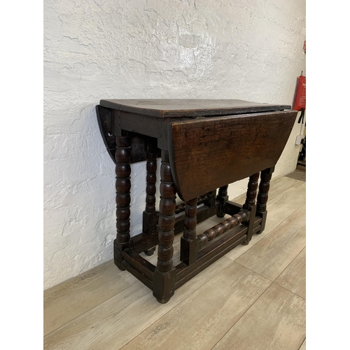 84 - An 18th century oak gate leg drop leaf dining table on bobbin supports