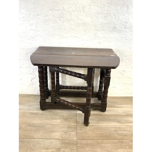 84 - An 18th century oak gate leg drop leaf dining table on bobbin supports