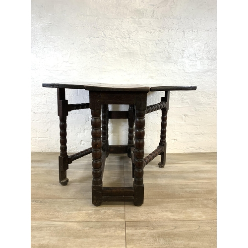 84 - An 18th century oak gate leg drop leaf dining table on bobbin supports