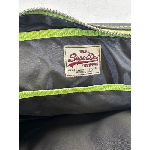 534 - A SuperDry black and green leatherette messenger bag