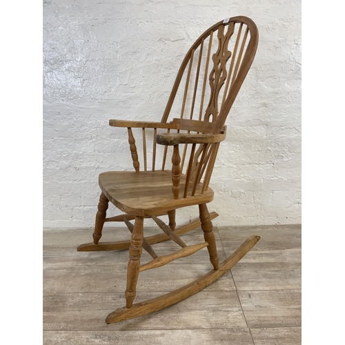 105 - A 19th century style oak Windsor rocking chair