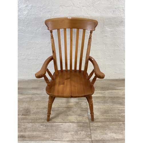 107 - A Victorian style pine spindle back farmhouse armchair