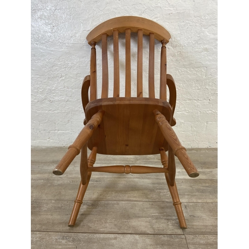 107 - A Victorian style pine spindle back farmhouse armchair